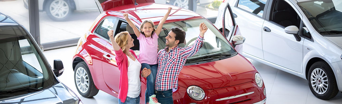 image of a family in front of a car celebrating