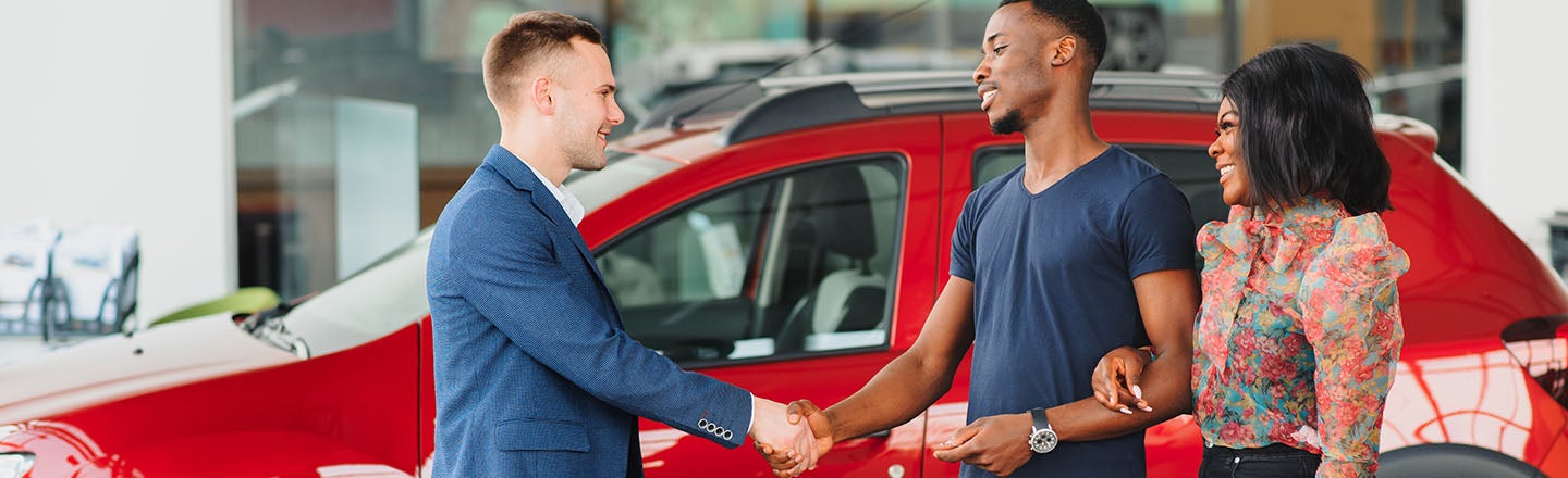 image of a couple with the man shaking the saleman's hand